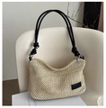 Detailed close-up of woven straw handbag on a white chair with elegant black leather brand tag - Black