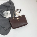 Dunkelbraune gewebte Shopper-Tasche mit Goldkette und Hirsch-Anhänger auf Weiß - Braun