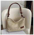 Close-up of woven straw bag with brown faux leather strap and brand logo detail - Dark Brown