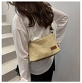 Detail of beige woven tote bag with brown leather handles and brand patch on back - Brown