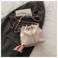 Detailed shot of pink embroidered bucket bag with pearl handle on dark blazer - Pavilion Pink