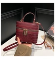 Detailed macro of burgundy crocodile texture box bag with gold metal hardware - Red