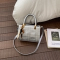 Chic silver quilted handbag with metallic finish and beaded charm on wood floor - Silver with Charm
