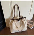 Primer plano del bolso tote de lona beige con cadena de perlas junto a la puerta - Blanco Roto