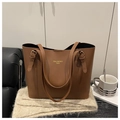 Détail du logo doré et des boucles latérales réglables sur un sac cabas en cuir marron - Marron