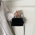 Minimalist black matte crossbody square bag with silver ring hardware on white shirt - Black