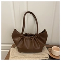 Detail of soft brown pleated cloud bag with gold logo on knit background - Brown