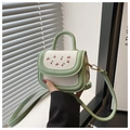 Detalle del mini bolso verde y blanco con estampados de cerezas y herrajes dorados - Verde