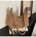 Détail du sac hobo kaki souple avec bandoulière réglable sur des livres anciens - Abricot Thé au Lait