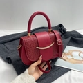 Bolso bandolera tejido rojo con hebilla dorada y doble correa sobre abrigo gris - Rojo