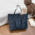 Gesteppte marineblaue Tragetasche mit Camouflage-Textur auf weißer Bettwäsche mit Winterdeko - Blau