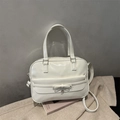 Weiße Shopper-Tasche aus Leder mit Schleifen-Detail und Herzanhänger auf rosa Büchern - Weiß