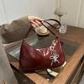 Fashionable burgundy crescent underarm bag with elegant pearl bow charm and glossy finish - Red