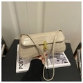 Detalle del bolso beige con patrón de cocodrilo y cierre dorado en revista - Caqui
