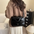 British retro black bowling bag with bow and heart pendant shown on model in home setting - Black