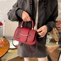 Elegante rote Schultertasche mit gewebter Klappe und goldenem Metallverschluss - Rot