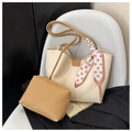 Elegante borsa tote crema con pochette marrone e foulard a pois su sedia d'arte - Cachi