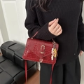Borsa a mano bordeaux effetto coccodrillo con fibbia dorata e ciondolo indossata da modella - Con Ciondolo / Rosso