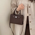 Detail of dark brown leather handbag with metallic turn-lock and lychee grain texture - No Pendant / Brown