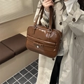 Brown vintage faux leather tote bag with bow detail and heart charm in a lifestyle setting - Tan
