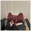 Dettaglio ravvicinato della borsa sottobraccio in pelle scamosciata bordeaux e fibbia - Rosso