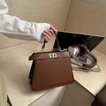 Elegant brown leather trapezoid handbag with gold rotating lock and single handle - Brown
