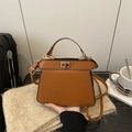 Brown leather trapezoid handbag with gold twist lock and adjustable shoulder strap - Brown