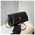 Close-up of black leather square bag with chunky gold chain and metal twist lock detail - Black