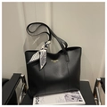 Detail of black leather tote bag featuring a decorative geometric silk scarf on handle - Black
