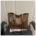 Close-up of brown tote bag featuring golden logo and stylish geometric silk scarf detail - Brown