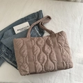 Dusty pink quilted puffer tote bag with wave stitching on a white textured background - Khaki