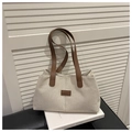 Close-up of beige linen tote bag with brown leather handles and square patch detail - Brown