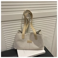 Detail of linen canvas tote bag with brown leather straps and smooth stitching texture - Khaki