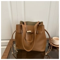 Detail of caramel leather bucket bag featuring gold twist lock and green suede lining - Brown