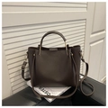 Detail of dark brown lychee leather texture and golden metal hardware on a bucket bag - Coffee
