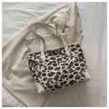 Detailed shot of leopard print tote bag with cream leather trim and metal hardware logo - White