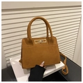 Detail einer braunen matten Trapez-Handtasche mit goldenem Drehverschluss und Griffen - Braun