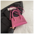 Detailed view of pink lambskin plush mini handbag on a black blazer with adjustable strap - Pink