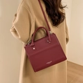 Burgundy square crossbody bag shown with a camel wool coat in a stylish lifestyle setting - Burgundy