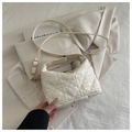 Detail van hart-gewatteerd patroon op crème crossbodytas met gouden metalen accenten - Wit