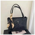 Dettaglio della borsa tote nera con cuciture a contrasto e sciarpa decorativa in seta - Nero