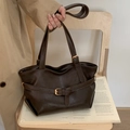 Bolso tote minimalista en color marrón oscuro con hebillas doradas y acabado mate - café