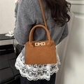 Brown matte finish crossbody handbag with golden clasp shown on a model - Brown