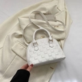 Bolso tipo concha blanco con textura de cuadros y herrajes dorados en un entorno de estilo - Blanco