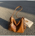 Close-up of brown vintage hobo bag featuring side zipper pocket and silver hardware - Brown