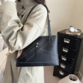 Borsa tote nera in pelle martellata con cuciture bianche e foulard indossata da modella - Nero