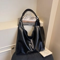 Minimalist black PU leather tote bag with a small pouch on a soft textured chair - Black
