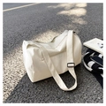 Detail of cream white travel bag showing front zipper pocket and adjustable shoulder strap - Off White
