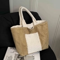Borsa tote in camoscio kaki e shearling bianco con manici soffici su una sedia - Cachi