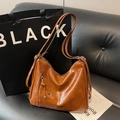 Borsa Hobo vintage in pelle cerata marrone con dettaglio nappa su divano in pelle - Marrone